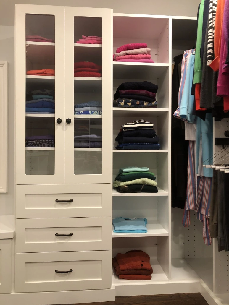 close-up of a closet with shelves, glass doors and drawers